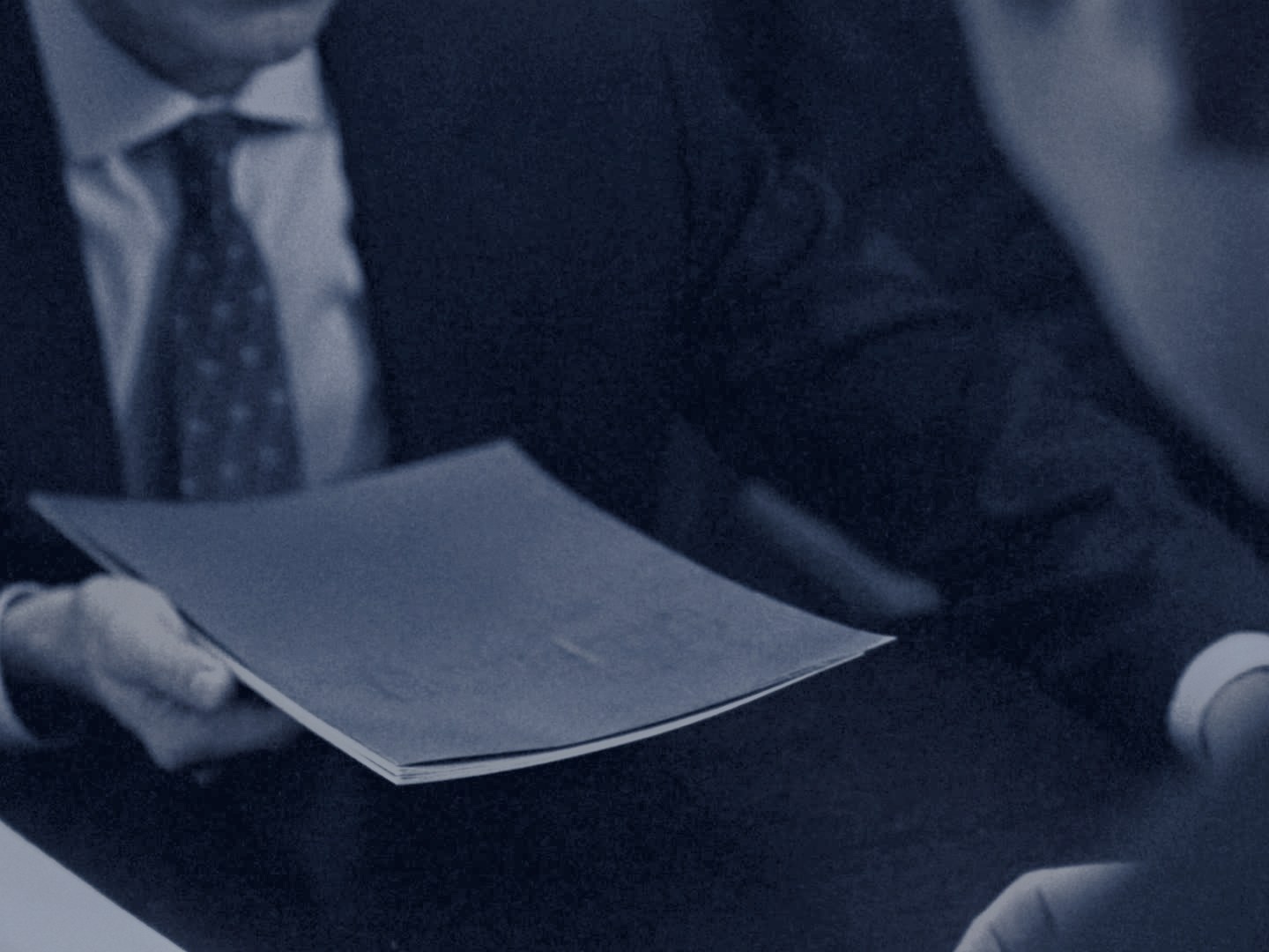 Un dossier de mission remis entre deux professionnels